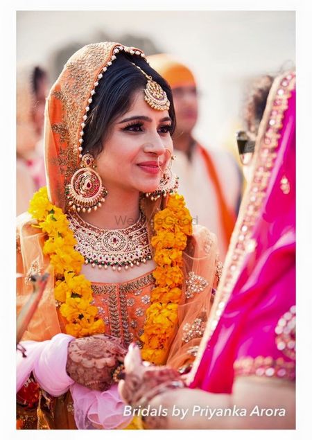 Bride in Orange Dupatta and Gold Jewelry