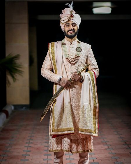 Photo of royal groom look with pastel sherwani and necklace
