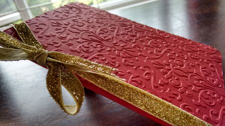 red embossed raised card with gold ribbon