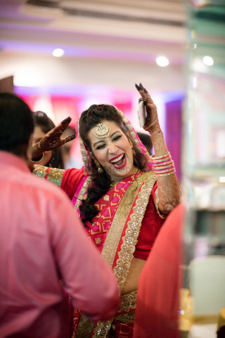 Photo of Fun bridal portrait with bride in red saree