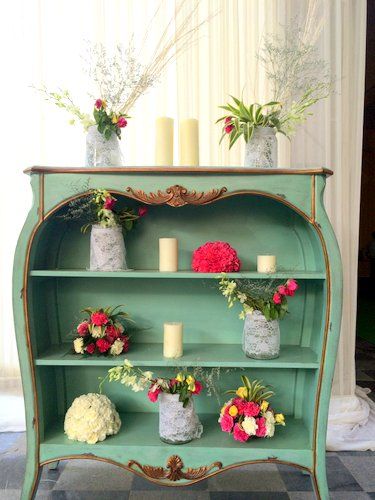 Photo of mint colored wooden chest with candles and flower arrangement