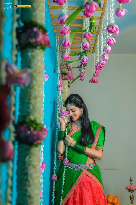 Photo of Bride in a green and coral lehenga saree.