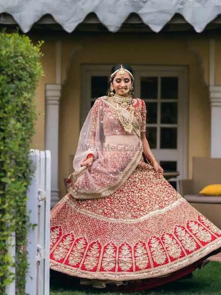 twirling bride shot in a red lehenga with gold work