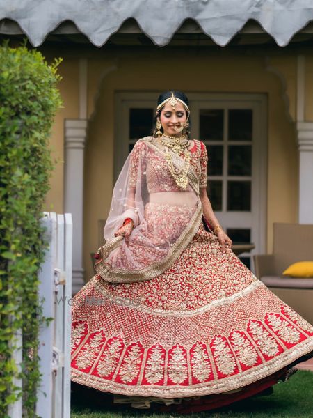 twirling bride shot in a red lehenga with gold work