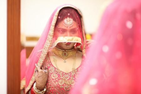 Bride Covering Face and Looking into Mirror
