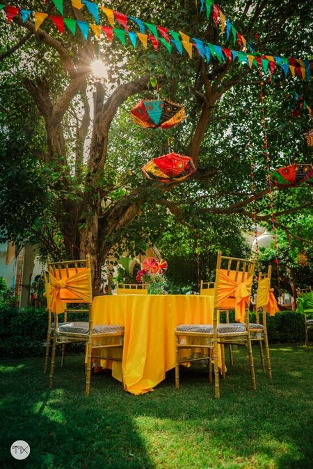 Photo of Yellow table settings and chair decor for an outdoor ceremony.