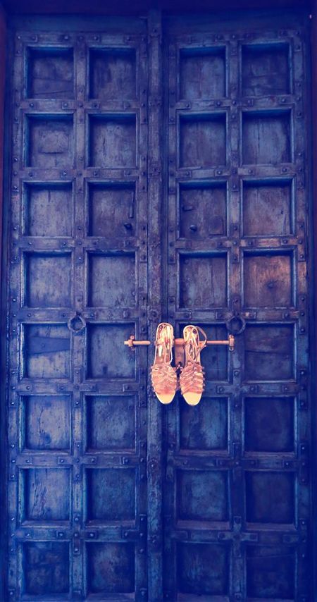 Photo of Bridal Shoes Hung on Royal Door Latch
