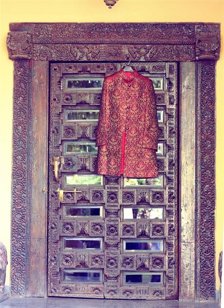 Deep Red Sherwani Hung on Royal Door