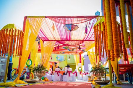 Photo of Colorful Mehendi Decor Tent with Props and Florals
