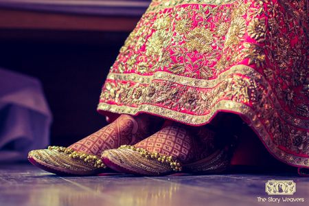 Bride wearing juttis below lehenga
