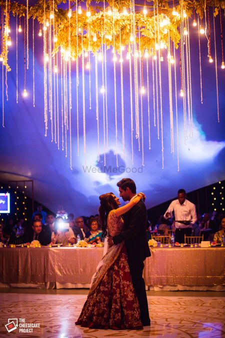 Photo of Couple dancing under chandelier with fairy lights