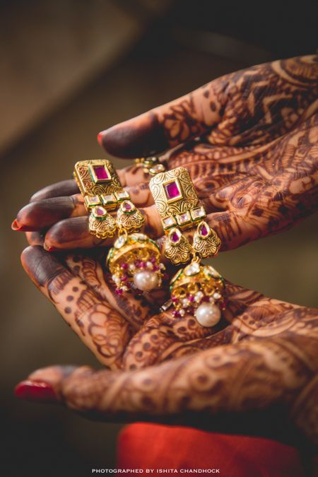 Bride Holding Pink and Gold Polki Danglers