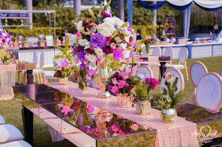 Long glass table decorated with floral vases.