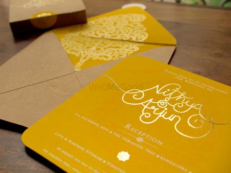 Photo of yellow and brown invitation card with tree of life motif