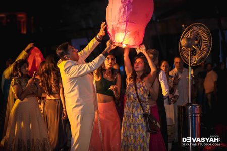 Guests Launching Flying Paper Lanterns at Wedding