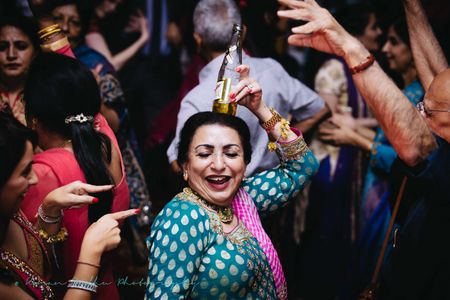 Photo of Mother of the Bride Dancing with Bottle on the Head