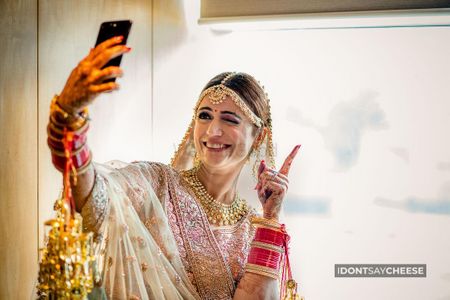Photo of wedding day bridal portrait taking a selfie