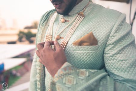 offbeat groom sherwani with pearl necklace