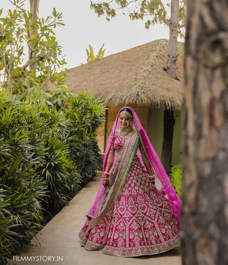 twirling bride in bright pink lehenga with green dupatta