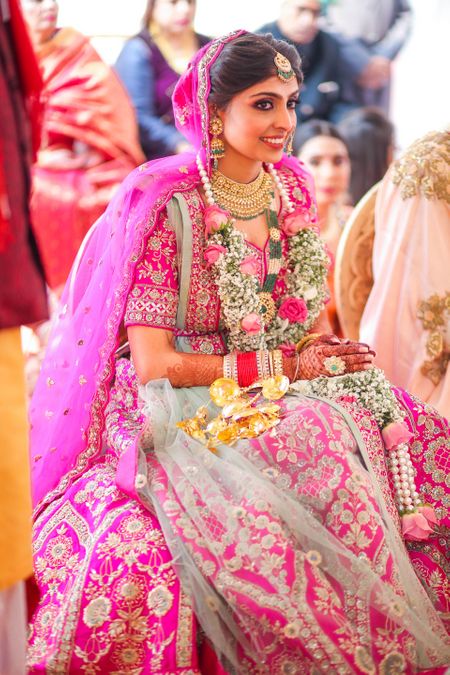 Bride dressed in a Fuschia pink lehenga on her wedding day.