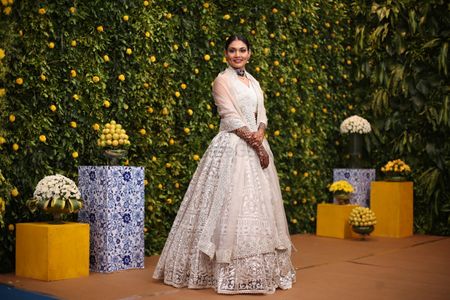 Photo of unique engagement look for bride in an ivory lace lehenga