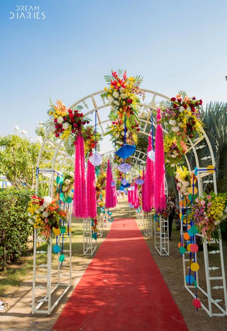 A quirky archway entrance with floral arrangements and other fancy elements.