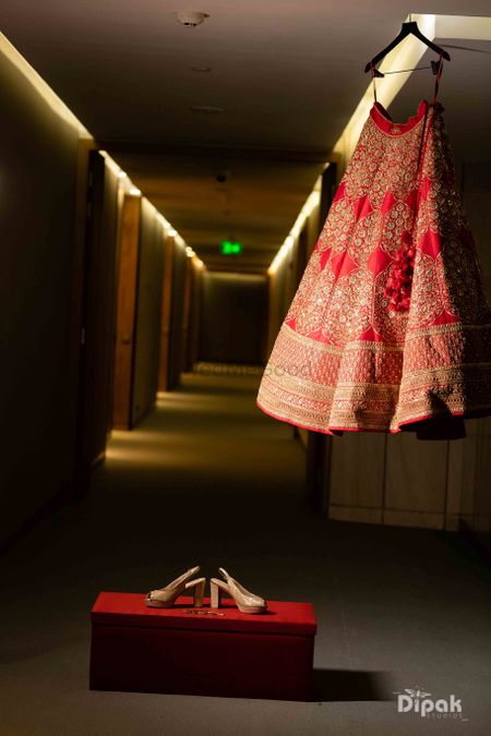 red and gold sabyasachi lehenga on hanger with box