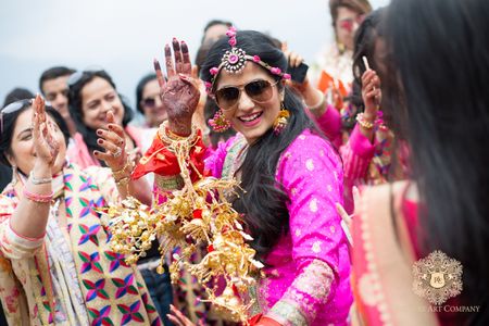 Photo of Bride Dancing with Kaleeras on Mehendi wearing Sunnies