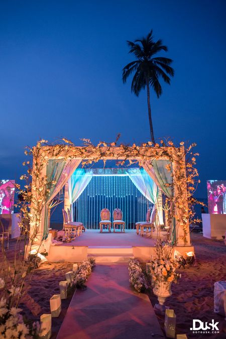 Photo of All white mandap decorated with flowers and foliage