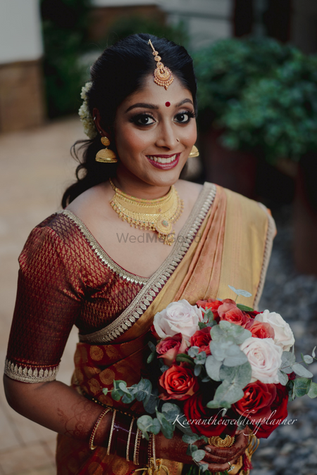 Photo of Bride wearing a beautiful silk saree with gold jewellery.