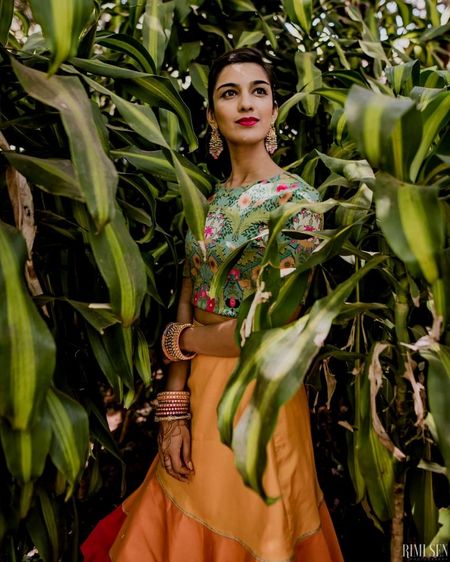 Photo of Bride wearing a printed crop top with a plain yellow skirt.