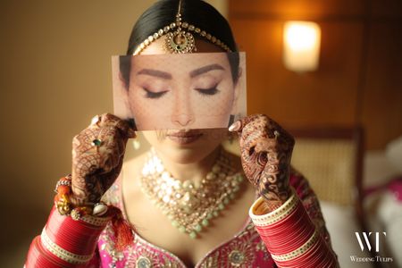 bridal makeup portrait with bride holding eye palette