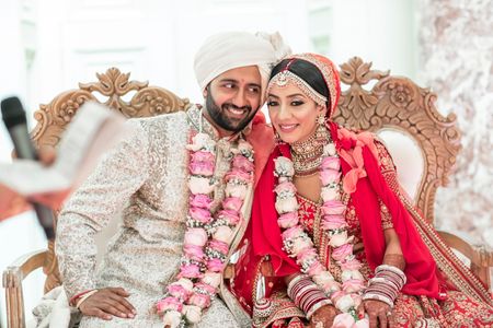 happy post wedding shot with pink jaimalas 