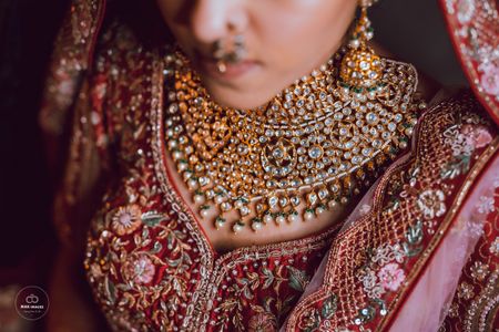 Uncut polki necklace paired with a red lehenga.