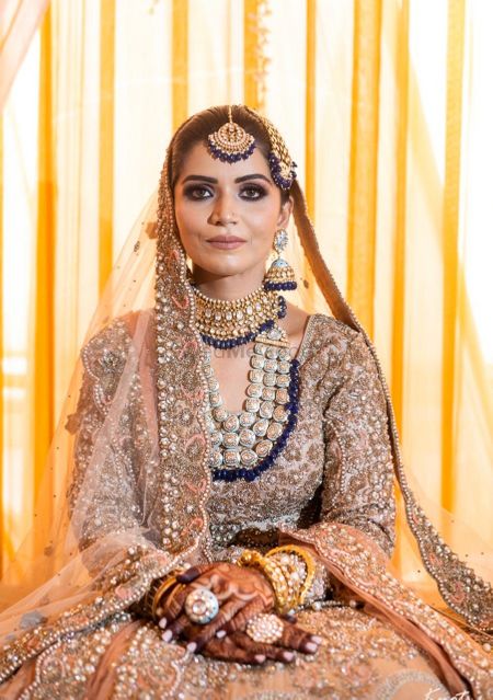Candid shot of a bride dressed in a heavy lehenga.