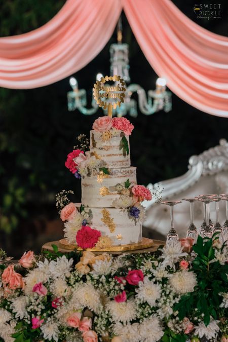 Three-tier wedding cake with flowers.