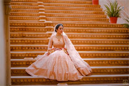 Bride dressed in a blush pink lehenga.