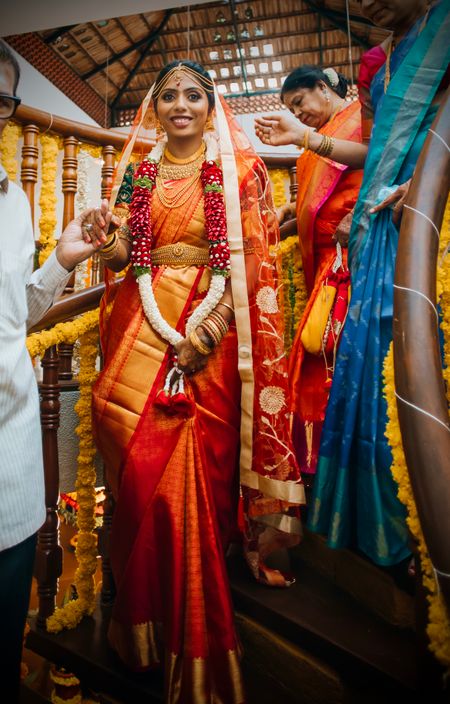 South Indian bride in a red and gold saree.