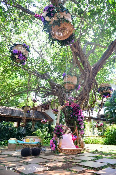Jhoola setup with purple flowers and cane baskets.