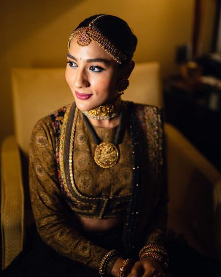 Bride wearing a jacket style blouse with her lehenga.