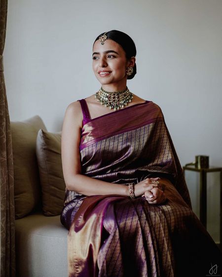 Photo of Bride wearing a minimalistic saree with a choker set.