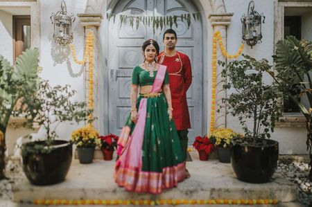 Bride and groom color-contrasting in green and red.