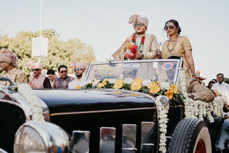 groom entering with his mother in a vintage car