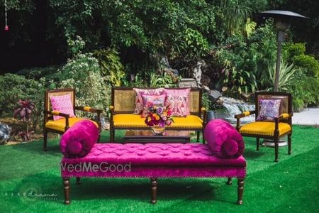 Photo of funky decor elements for mehendi with a fuchsia sofa