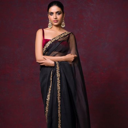 Black saree with a maroon velvet blouse.