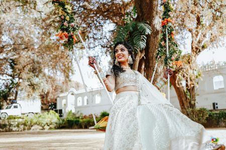 Candid shot of a Bride sitting on a swing.