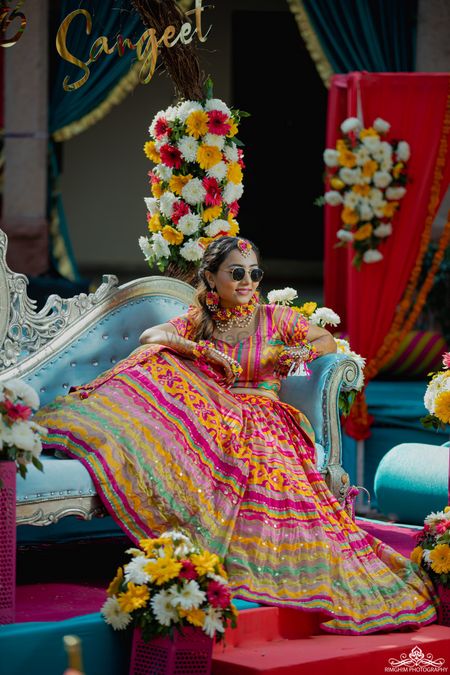 Bide wearing multi-coloured lehenga on mehendi.