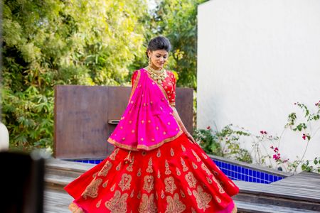 Twirling bride in red and pink lehenga