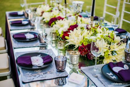 Photo of Purple theme table setting with floral arrangement