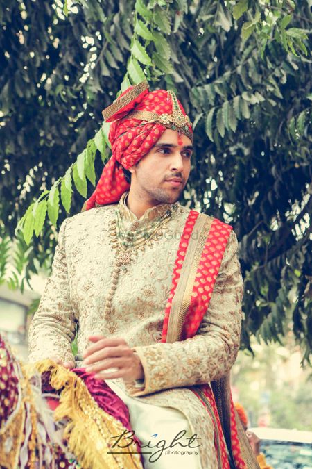 Off white and red embroidered sherwani with jewellery